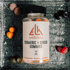 Bottle of Elk Wellness Turmeric + Ginger Gummies on a textured surface with gummy bears around.