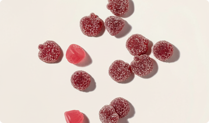 Red gummy candies on a light beige background